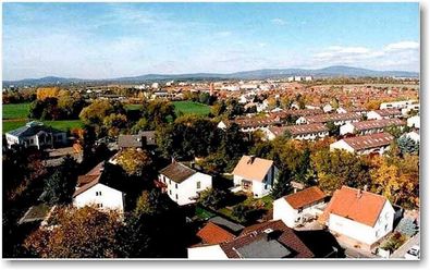 Die Luftaufnahme zeigt Liederbach am Taunus. es sind hauptsächlich die Dächer der Häuser zu sehen. Das obere drittel des Fotos ist blauer Himmel. 