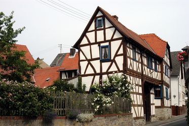 Das Foto zeigt ein Fachwerkhaus mit braunen Balken und weißem Putz. 