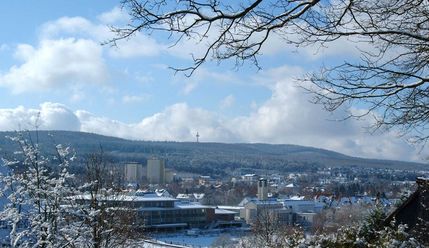 Taunusstein liegt in winterlicher Landschaft. Im Hintergrund in weiter Entfernung ist die hügelige Landschaft des Taunus zu sehen. Der Große Feldberg ist anhand seines markanten Turms zu erkennen. 